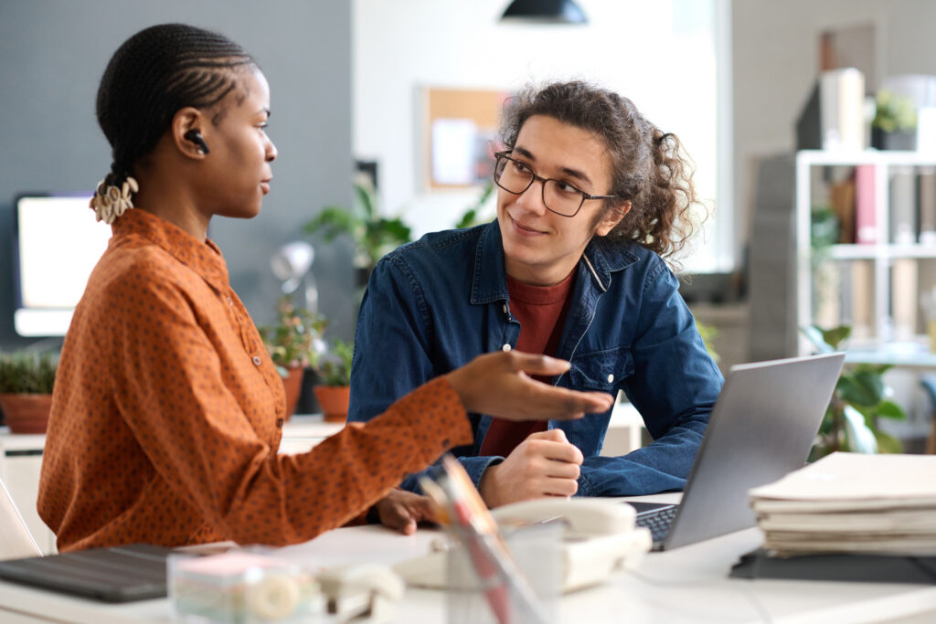 Mentor guiding a young professional during a workplace coaching session