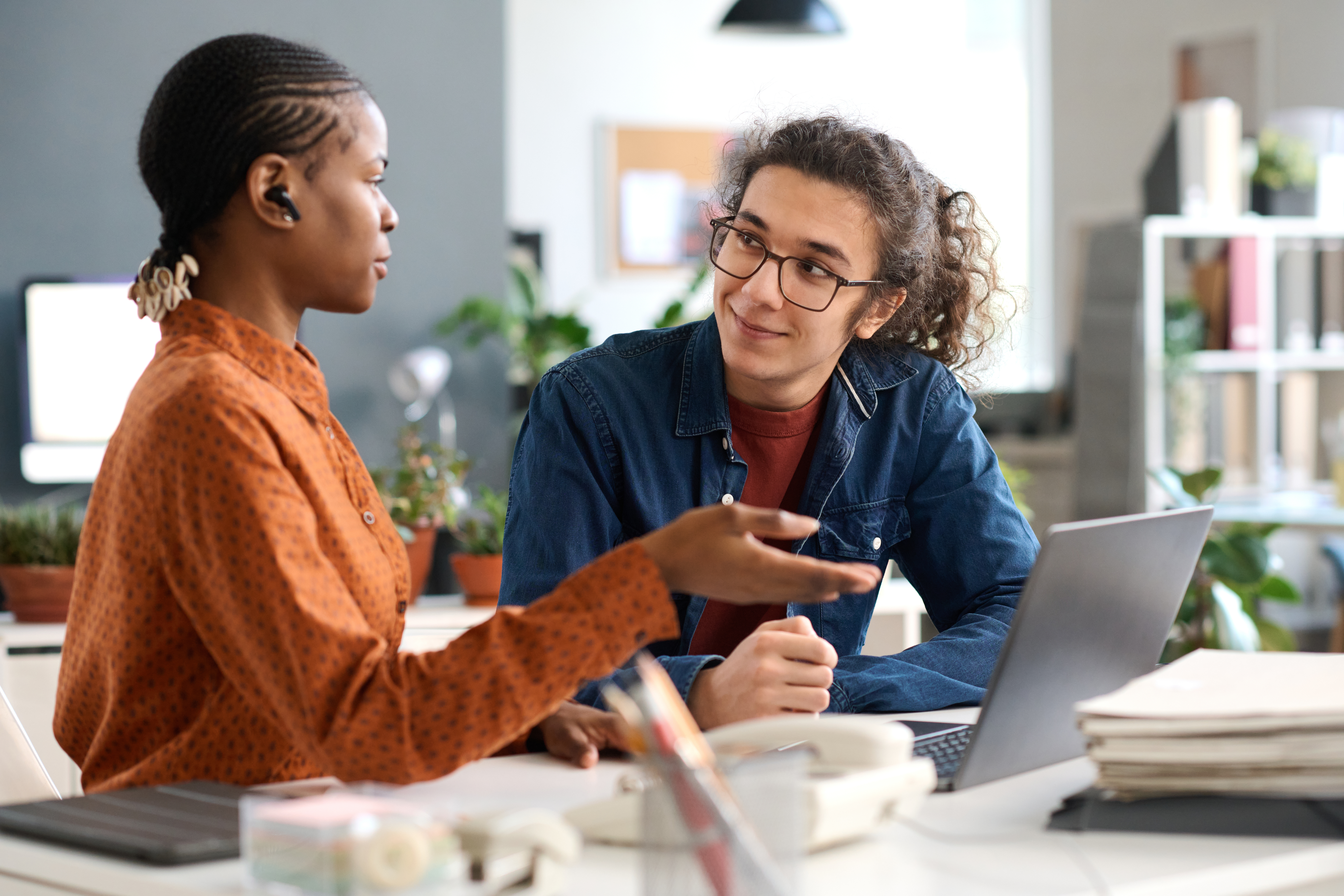 Mentor guiding a young professional during a workplace coaching session
