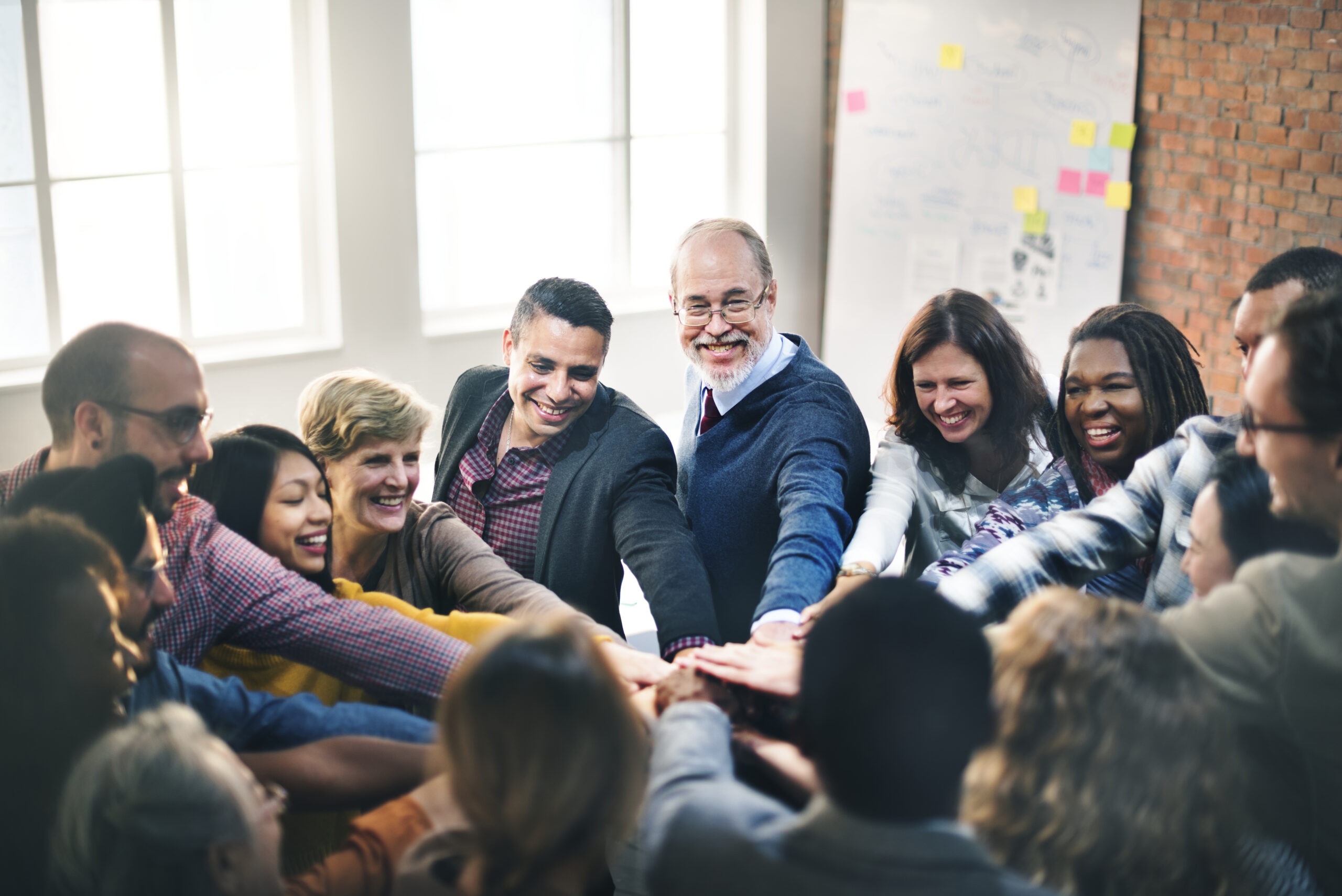 A diverse team joins hands to celebrate unity and a strong team culture.